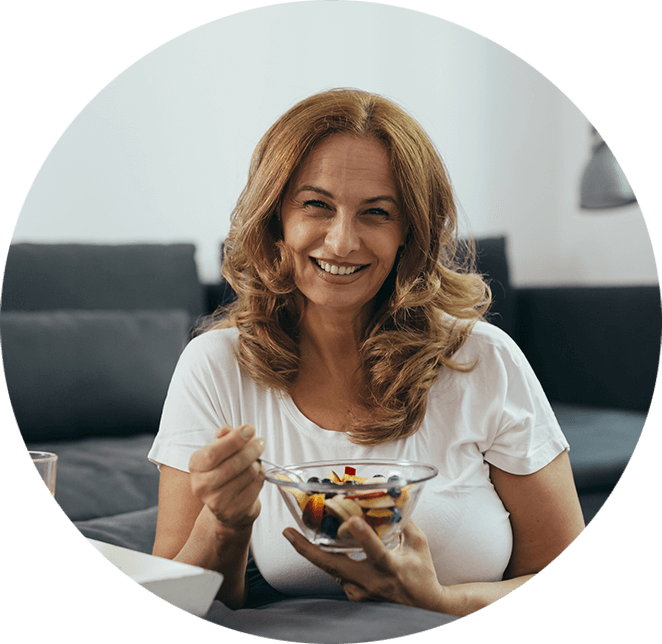 Very nice lady smiling about to eat while at home on her couch smiling