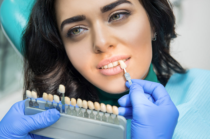 Very nice lady with dark hair and light eyes getting her teeth color matched