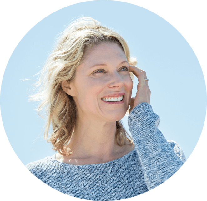 Very nice lady smiling with blonde hair outside with the sky in the background